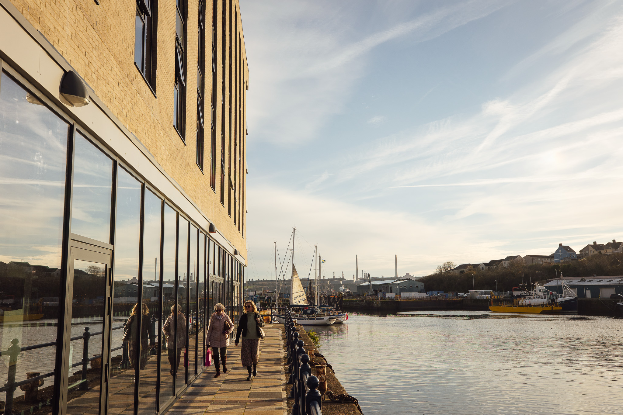 People walking next to the hotel at Milford Waterfront